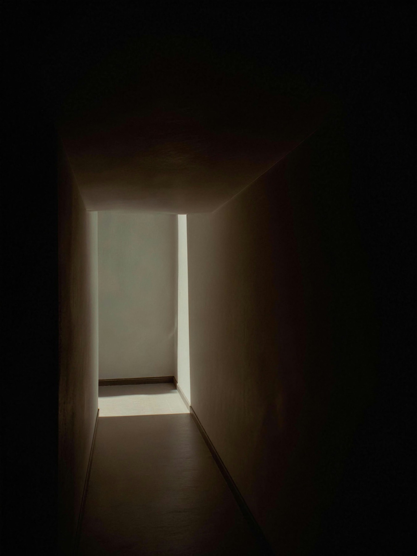 A facade at dusk, its openings lit warmly from within
